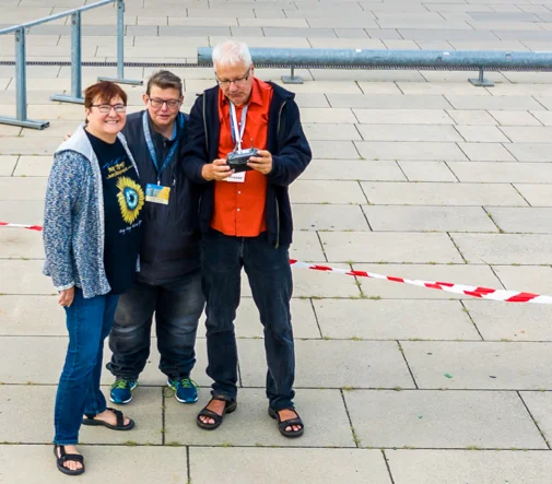 Drohnenaufnahme aus Potsdam: Drei Personen stehen auf einem Platz.
