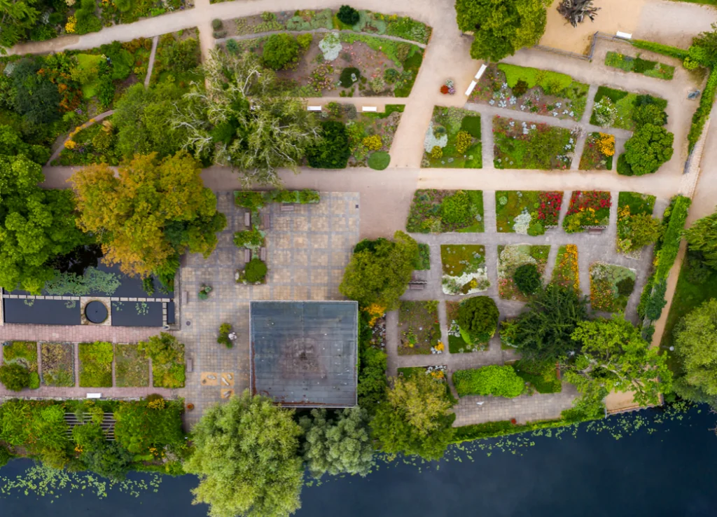 Eine Drohnenaufnahme aus Potsdam zeigt Beete und Bäume von oben.