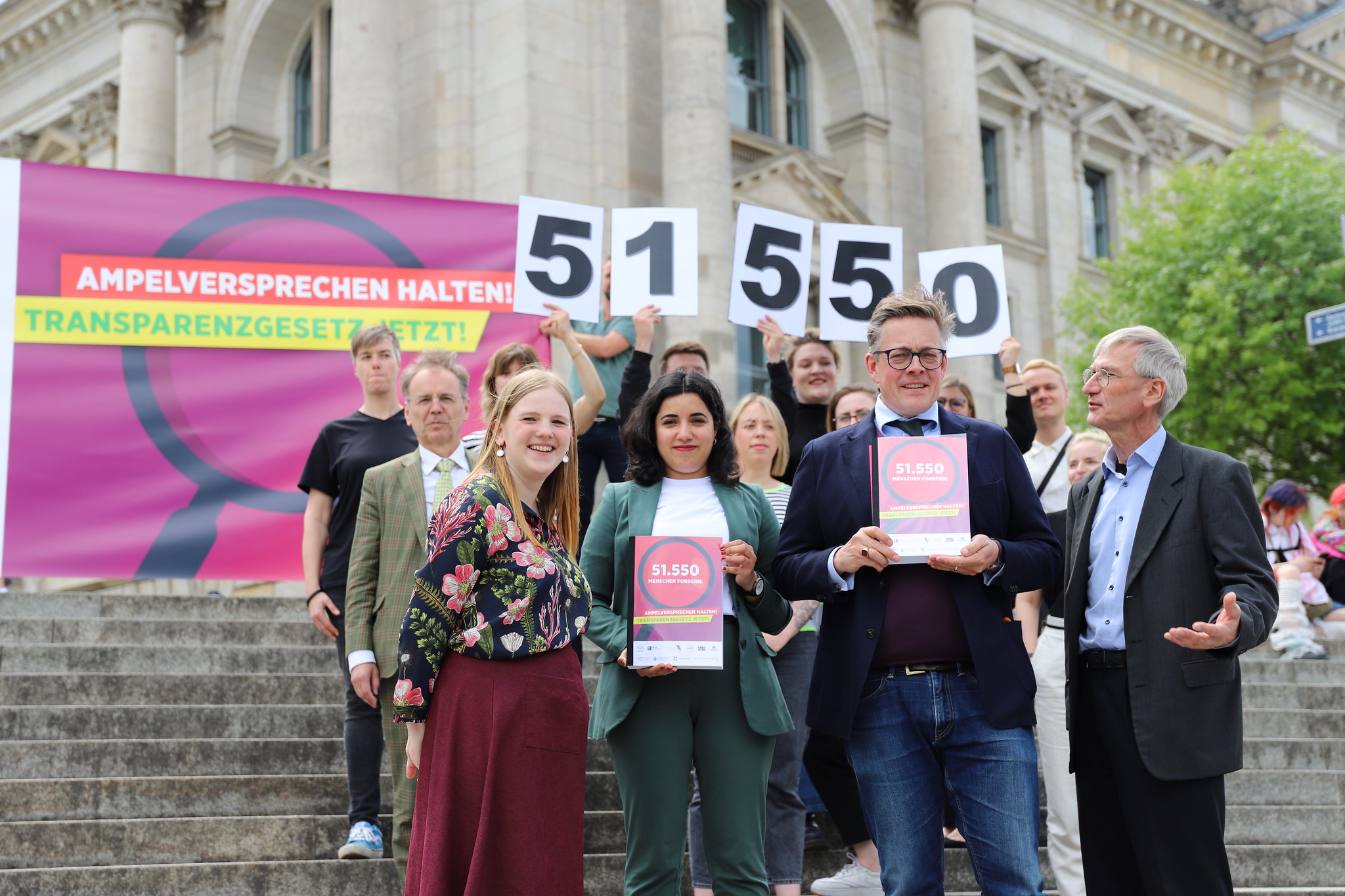 Ein Gruppenfoto vom Bündnis Transparenzgesetz. Die Zahl 51550 wird hochgehalten.