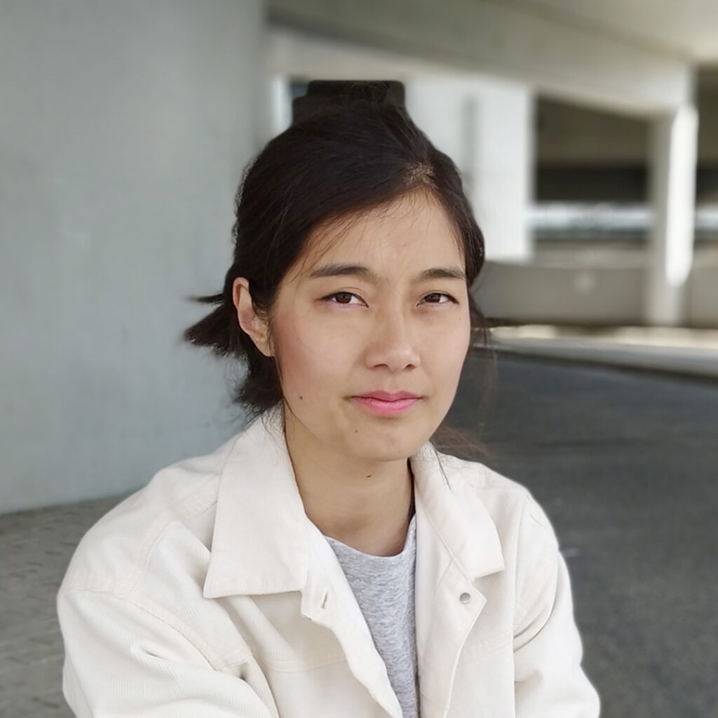 Victoria Kure-Wu, expert in user experience design, in front of a grey building facade.