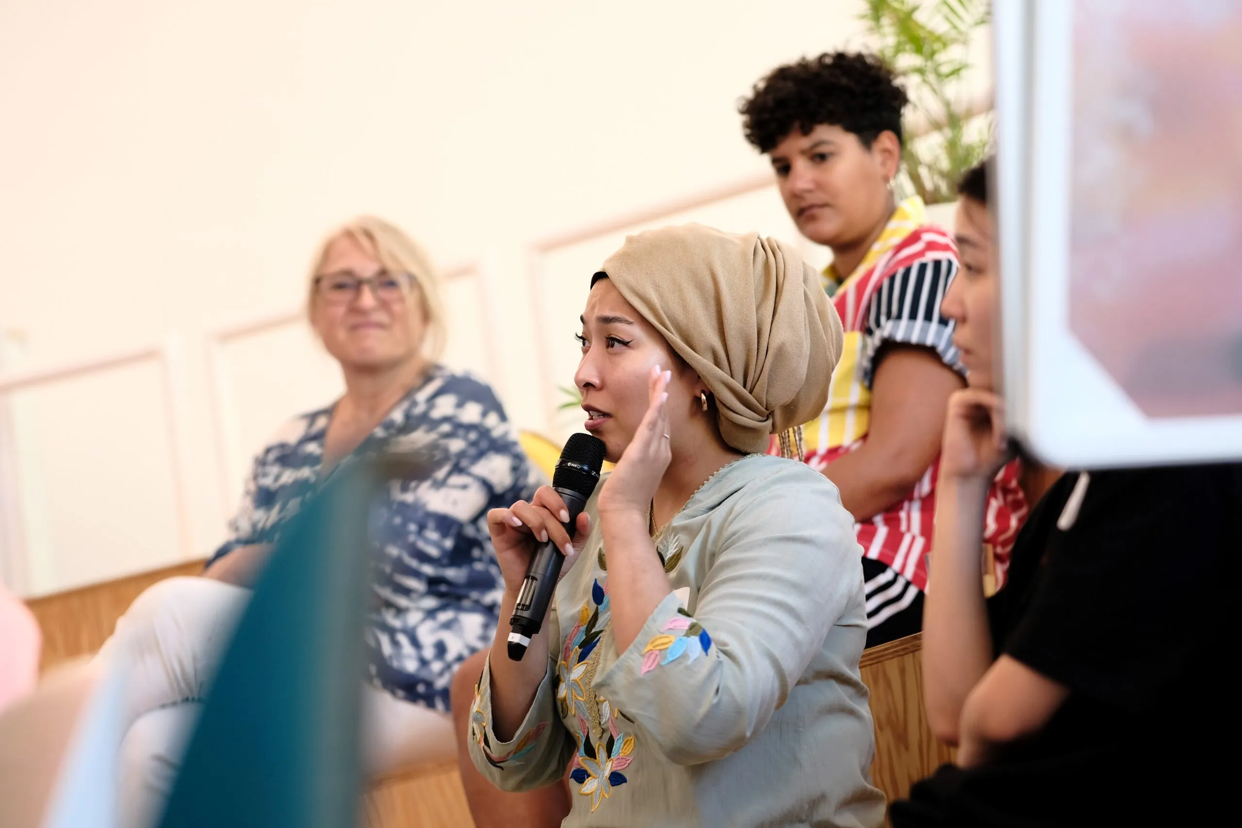 A person is sitting and speaking into a microphone.