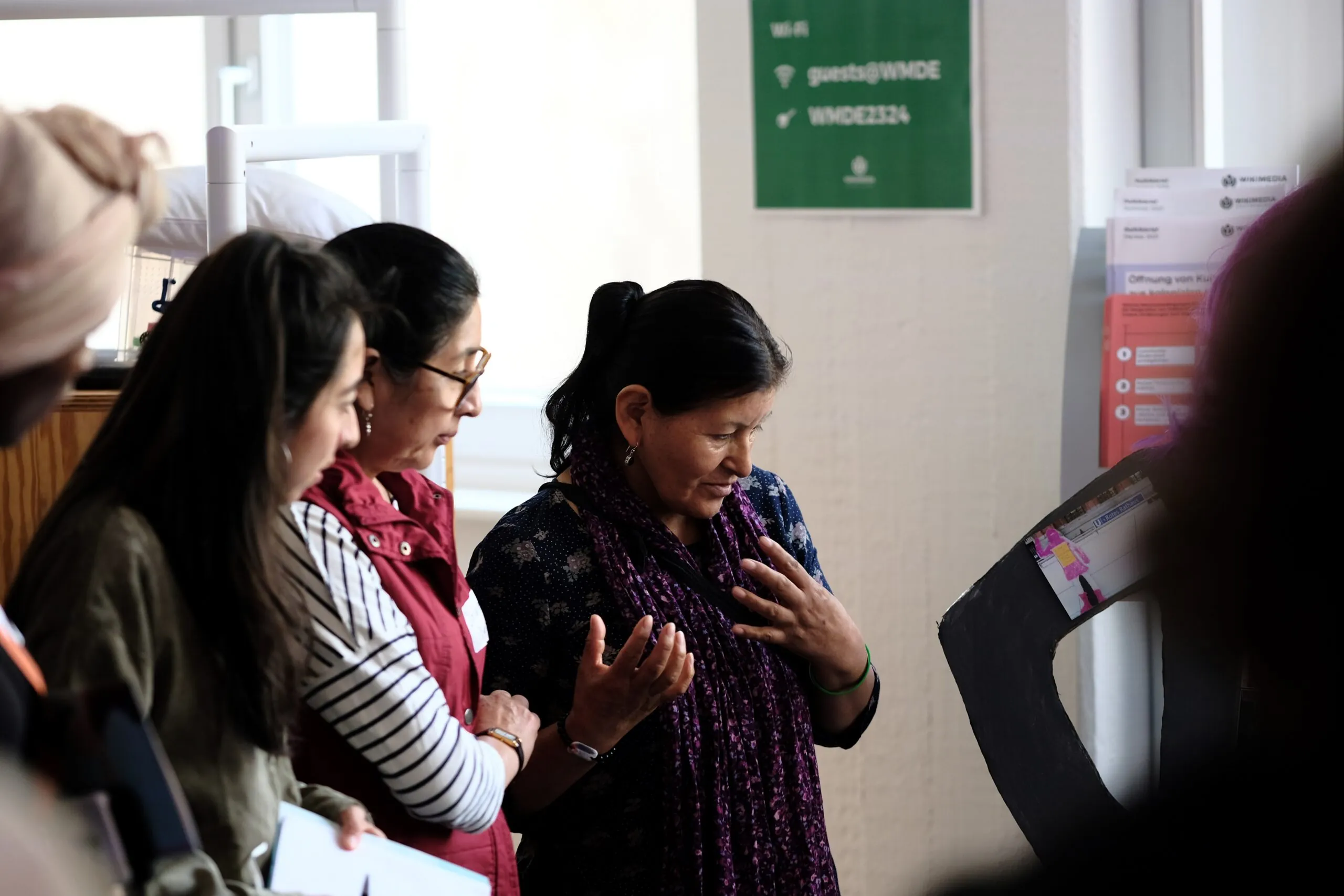 Three people are standing together looking at something.