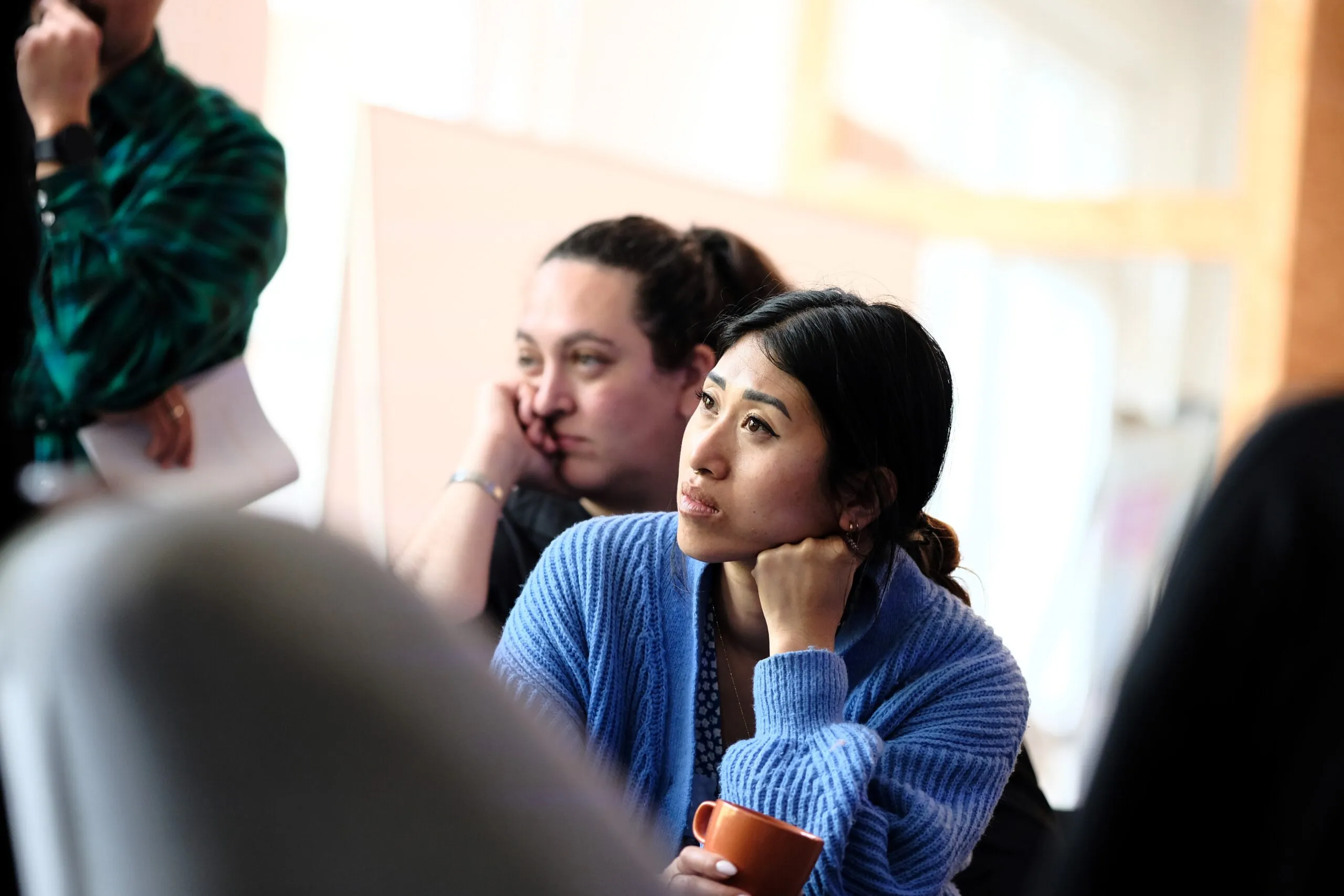 A person is sitting among other people and appears to be listening.