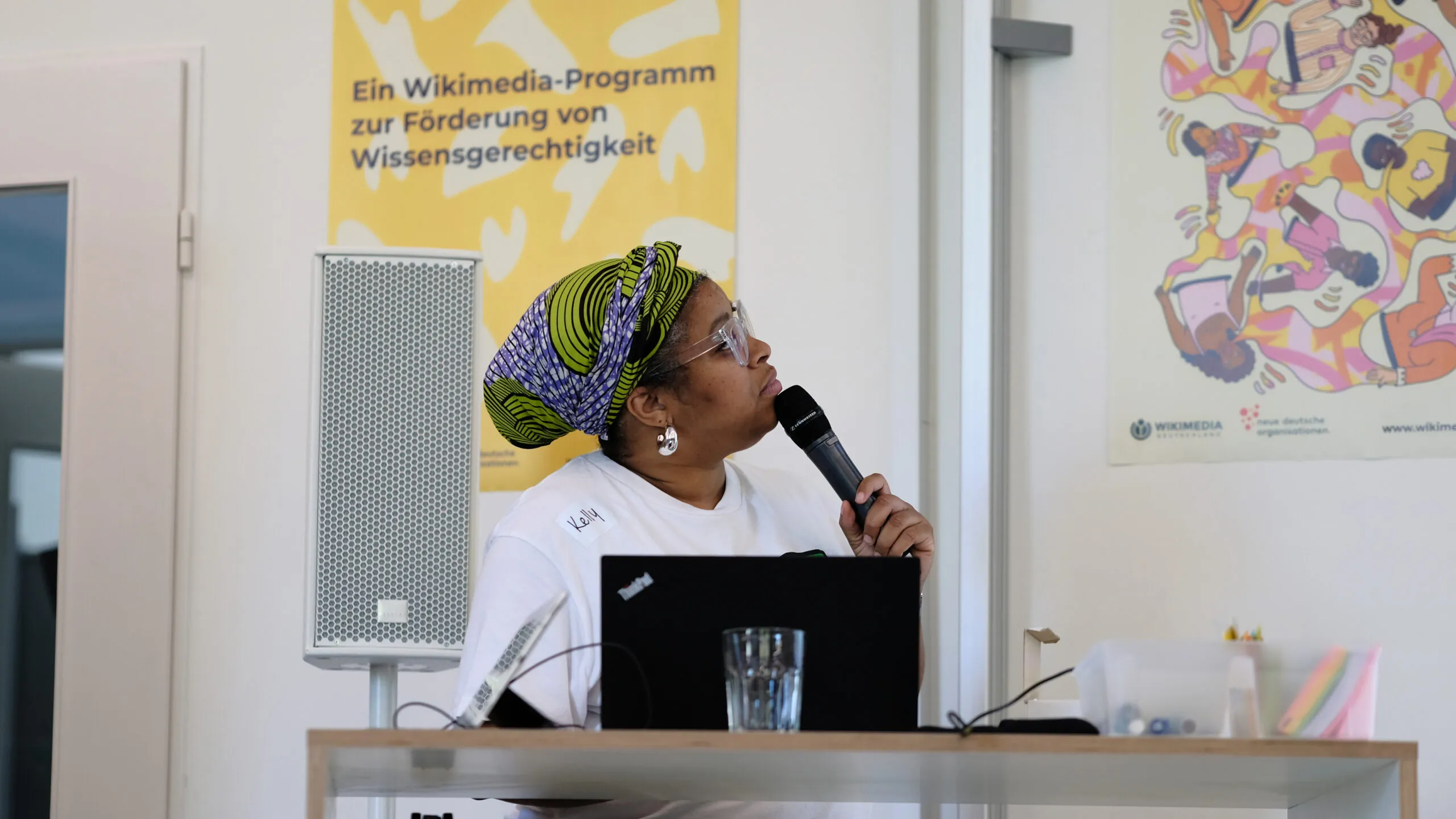 A person is looking to the right and holding a microphone in their hand.