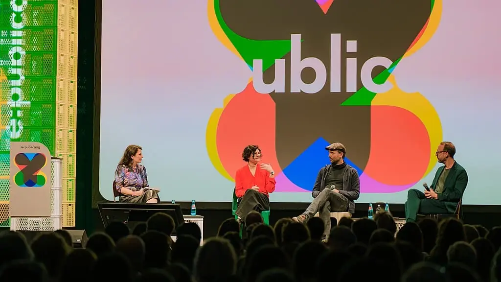Franziska Heine diskutiert im Panel mit Geraldine de Bastion, Marc-Uwe Kling und Markus Beckedahl. Im Hintergrund ist das re:publica-Logo zu sehen.